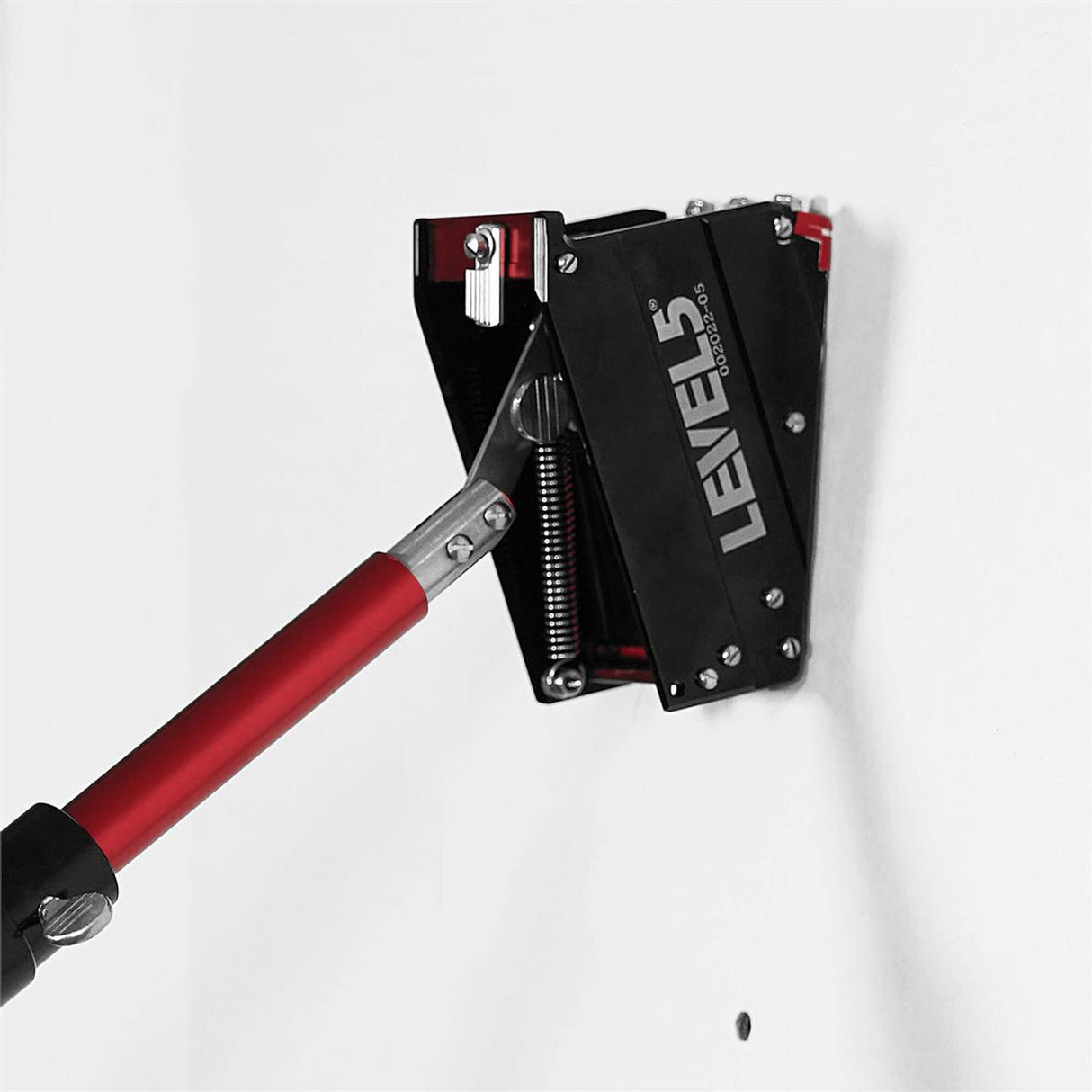 Close-up of Level 5 nail spotter on a Level 5 accessory handle filling nail recessions on a jobsite wall