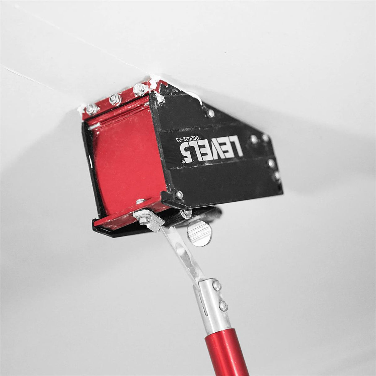 Close-up of Level 5 nail spotter on a Level 5 accessory handle filling nail recessions on a jobsite ceiling