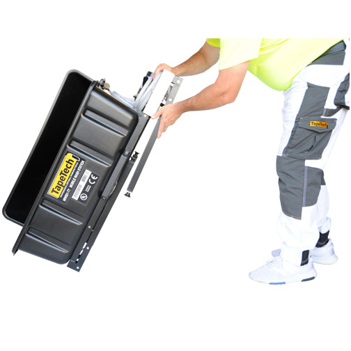 Person folding the table of a TapeTech Mobile Wash Station with black wash basin, hose, and sprayer attached