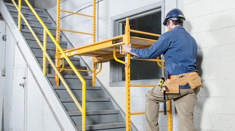 Drywall contractor setting up a scaffolding on the stairs