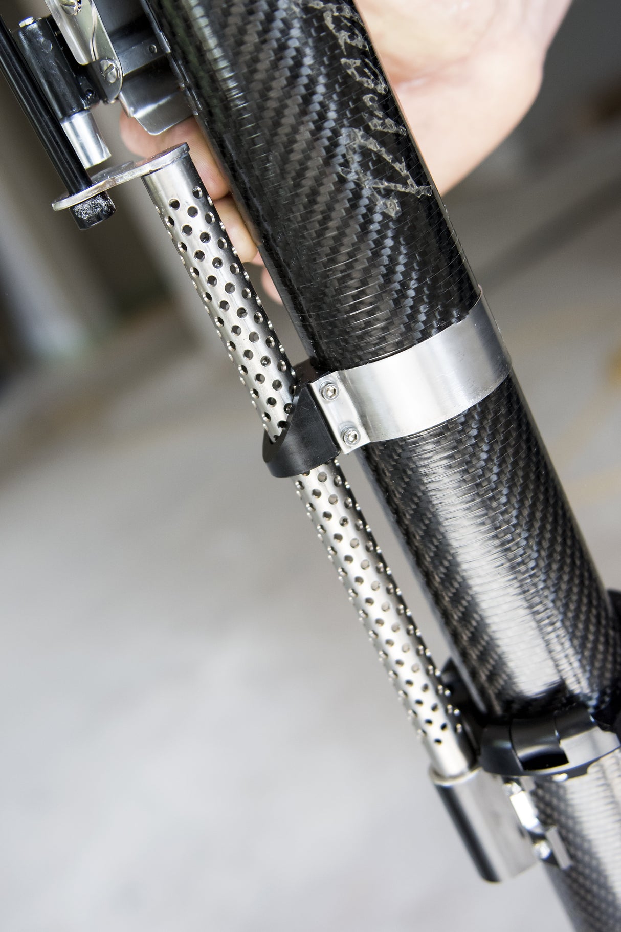 Close-up of hand holding black carbon fiber Columbia Sawed Off Predator Automatic Taper body at the job site